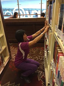 Sharon keeping the shelves tidy and making sure the books are correctly shelved.