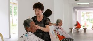 A retired hairdresser, Zhang Yu Lan, offers haircuts to elderly residents for free.