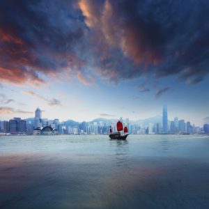 Traditional Chinese Junkboat sailing across Victoria Harbour at sunset, Hong Kong. © chinaface / Getty Images