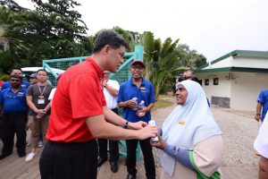 Chan Chun Sing, Secretary-General of National Trade Union Congress (NTUC) offering a token of appreciation to a worker who works in Sentosa, as part of the Young NTUC U Heart initiative.